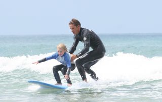surf tandem holding the kids surfing